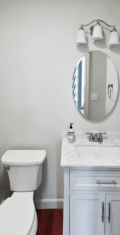 a bathroom with a toilet sink and mirror