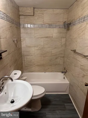 a bathroom with a sink a toilet and bathtub