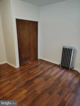 an empty room with wooden floor and closet