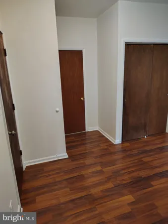 an empty room with wooden floor and entrance
