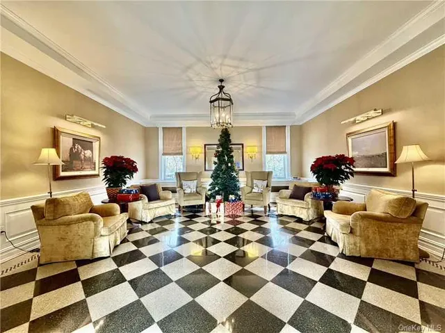 a living room with a black white checkered floor with a gaming machine and dining chairs