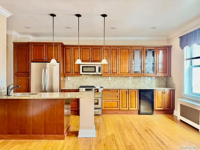 a large kitchen with stainless steel appliances kitchen island a large counter top a stove and a refrigerator