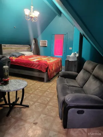 a bedroom with a bed and a chandelier