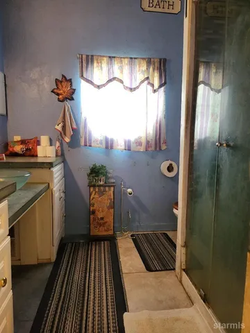 a bathroom with a glass door shower and a sink