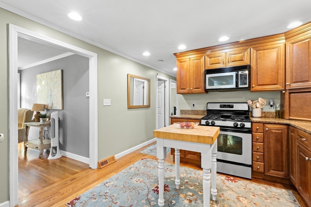 35 Memorial Drive Methuen, MA 01844 - Photo 12 of 42 a kitchen with stainless steel appliances granite countertop a stove a sink and a microwave