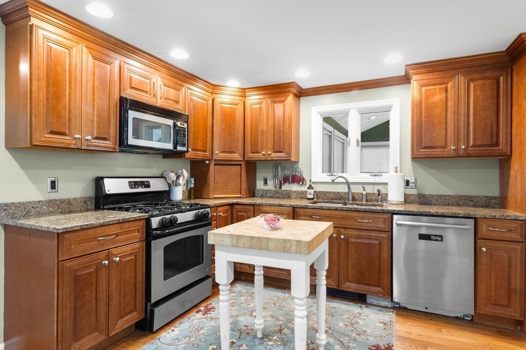 35 Memorial Drive Methuen, MA 01844 - Photo 10 of 42 a kitchen with stainless steel appliances granite countertop a stove a sink dishwasher and a microwave oven with cabinets