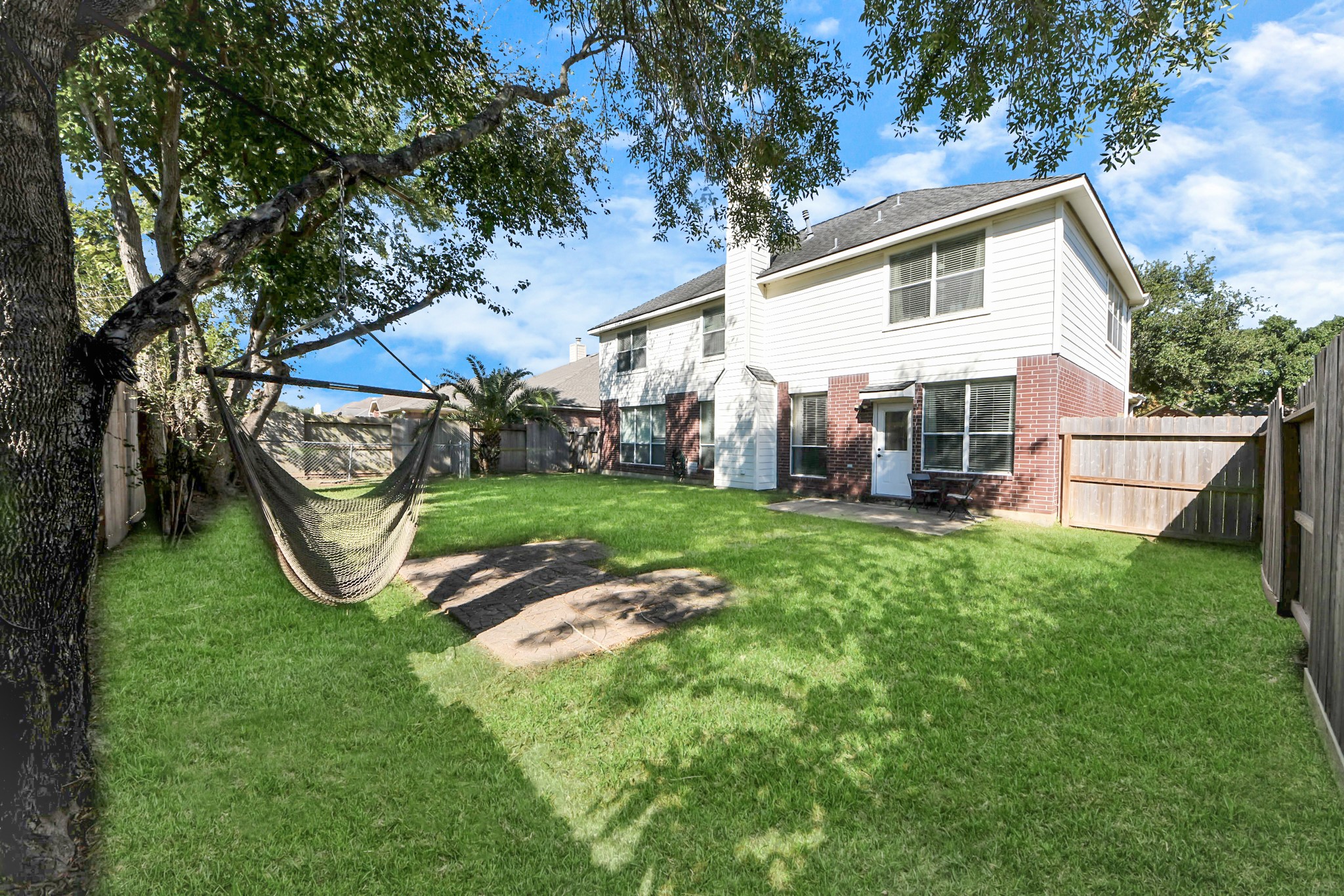 13635 Treebank Lane Houston, TX 77070 - Photo 19 of 26 a view of a white house with a big yard plants and large trees