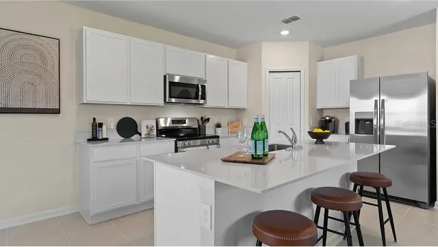 a kitchen with stainless steel appliances a microwave sink and refrigerator