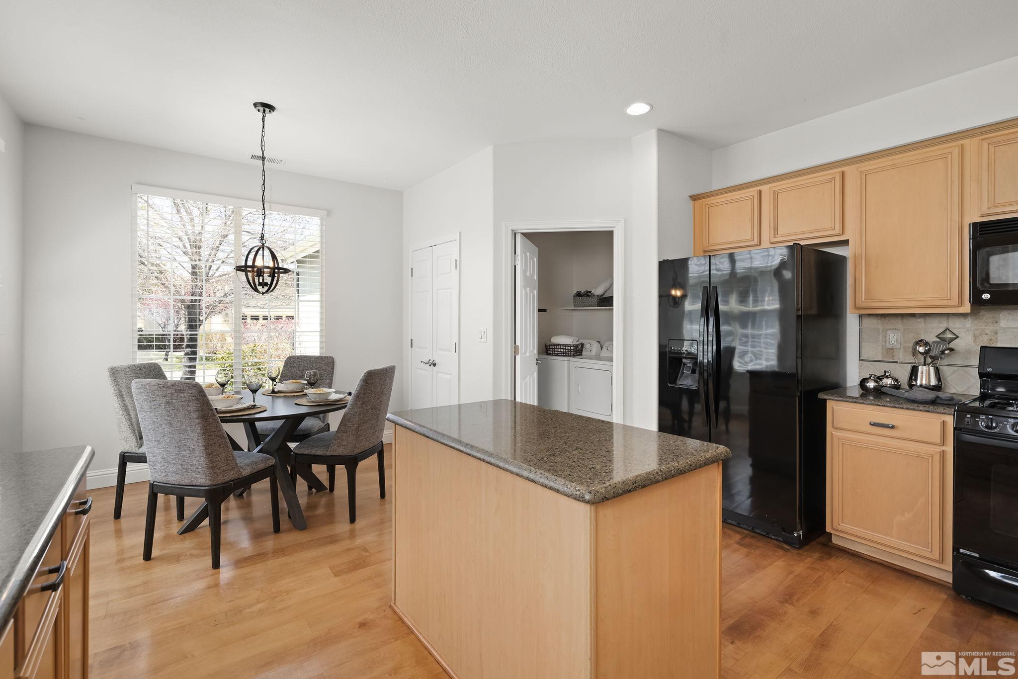 10414 Rockport Lane Reno, NV 89521 - Photo 9 of 22 a kitchen with refrigerator a dining table and chairs