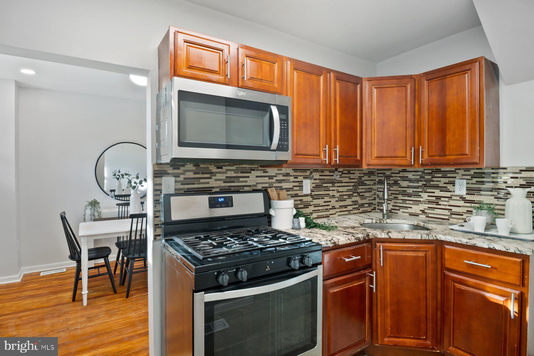 101 Willow Spring Road Dundalk, MD 21222 - Photo 11 of 28 a kitchen with granite countertop wooden cabinets stove top oven and sink