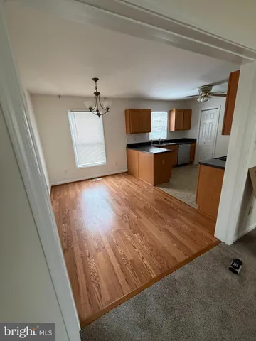 a view of a hallway with wooden floor and cabinet