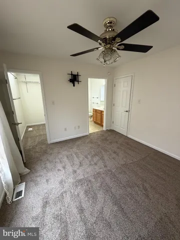 en empty room with windows and ceiling fan