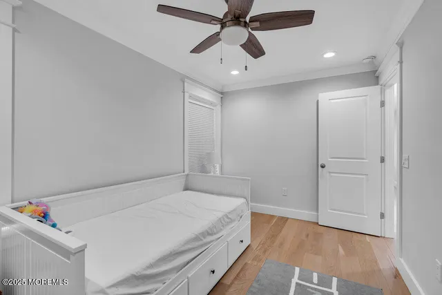 a bedroom with a bed and a chandelier fan