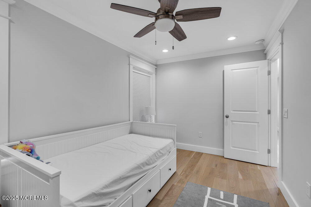 601 Ocean Road Spring Lake Heights, NJ 07762 - Photo 22 of 41 a bedroom with a bed and a chandelier fan