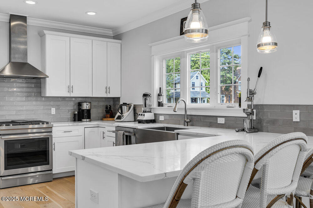 601 Ocean Road Spring Lake Heights, NJ 07762 - Photo 3 of 41 a kitchen with kitchen island granite countertop a stove a sink a dining table and chairs