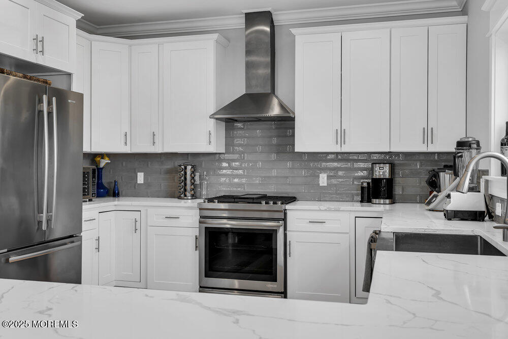 601 Ocean Road Spring Lake Heights, NJ 07762 - Photo 4 of 41 a kitchen with stainless steel appliances granite countertop a stove a refrigerator and a white cabinets
