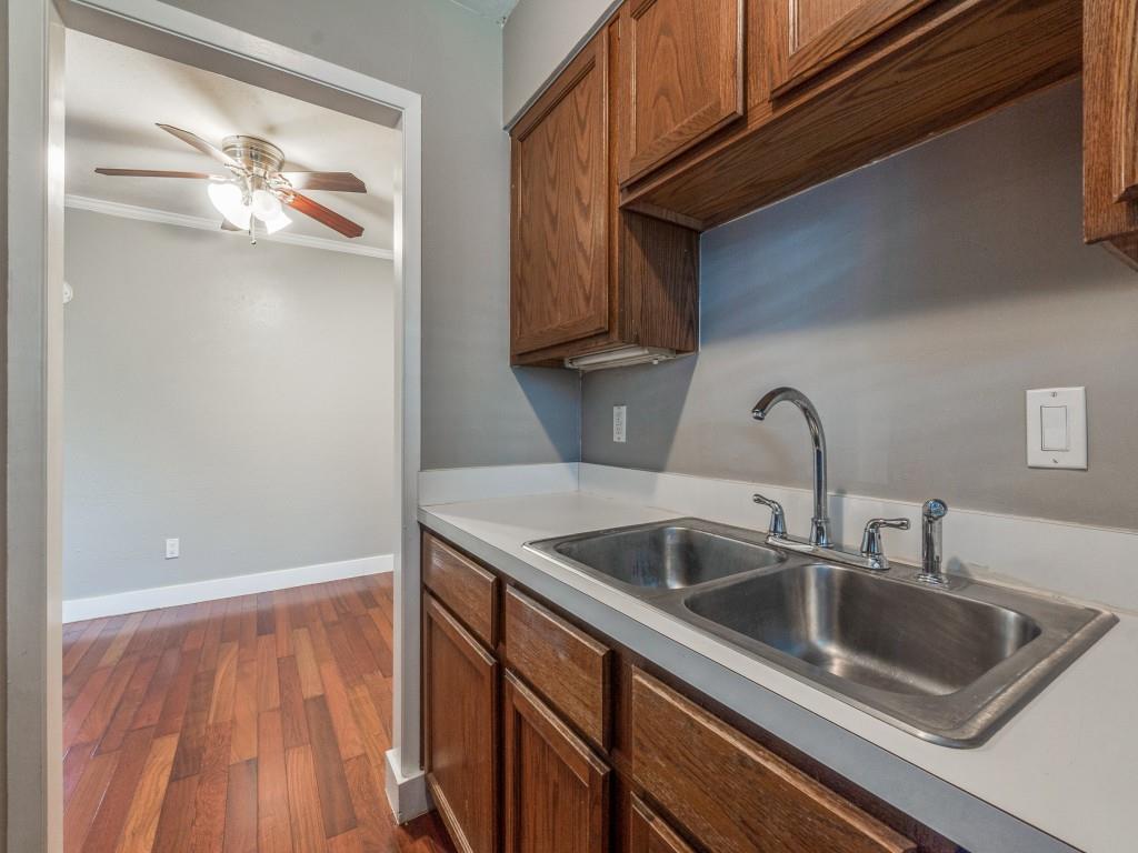 3921 Inwood Road, Unit 2015 Dallas, TX 75209 - Photo 7 of 12 Kitchen featuring dark wood-type flooring, brown cabinets, ornamental molding, a ceiling fan, and light countertops