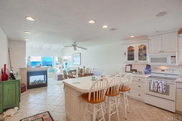 a open kitchen with stainless steel appliances kitchen island granite countertop a stove a sink a refrigerator and a microwave