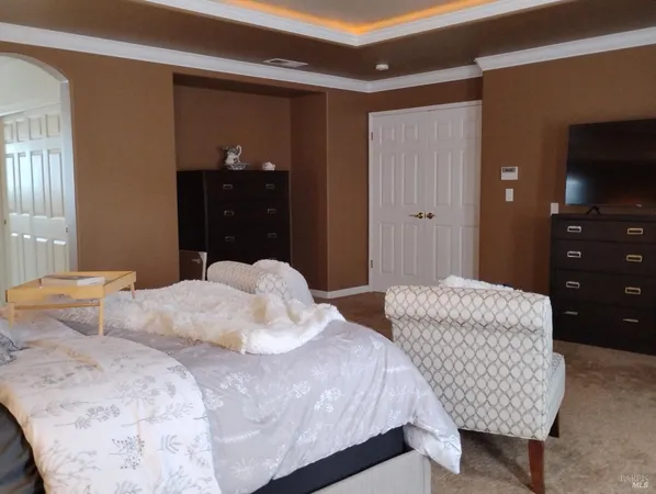 a bedroom with a bed and a lamp on dresser