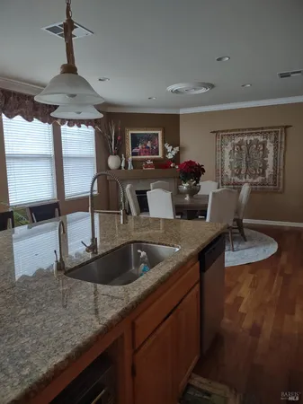 a kitchen with granite countertop a sink and a refrigerator