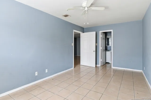 an empty room with closet and fan