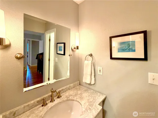 a bathroom with a granite countertop sink and a mirror