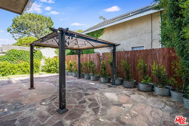 a view of a patio with table and chairs under an umbrella