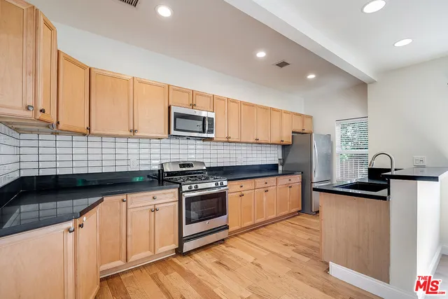 a kitchen with granite countertop a sink stove and cabinets