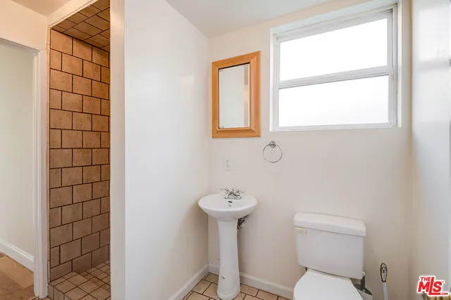 a bathroom with a sink a toilet and mirror