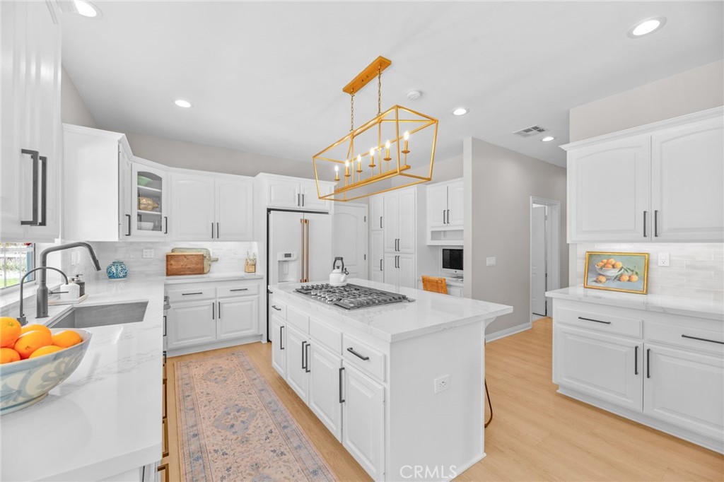 30702 Cll Pina Colada Temecula, CA 92591 - Photo 37 of 75 a kitchen that has a lot of cabinets in it and wooden floors