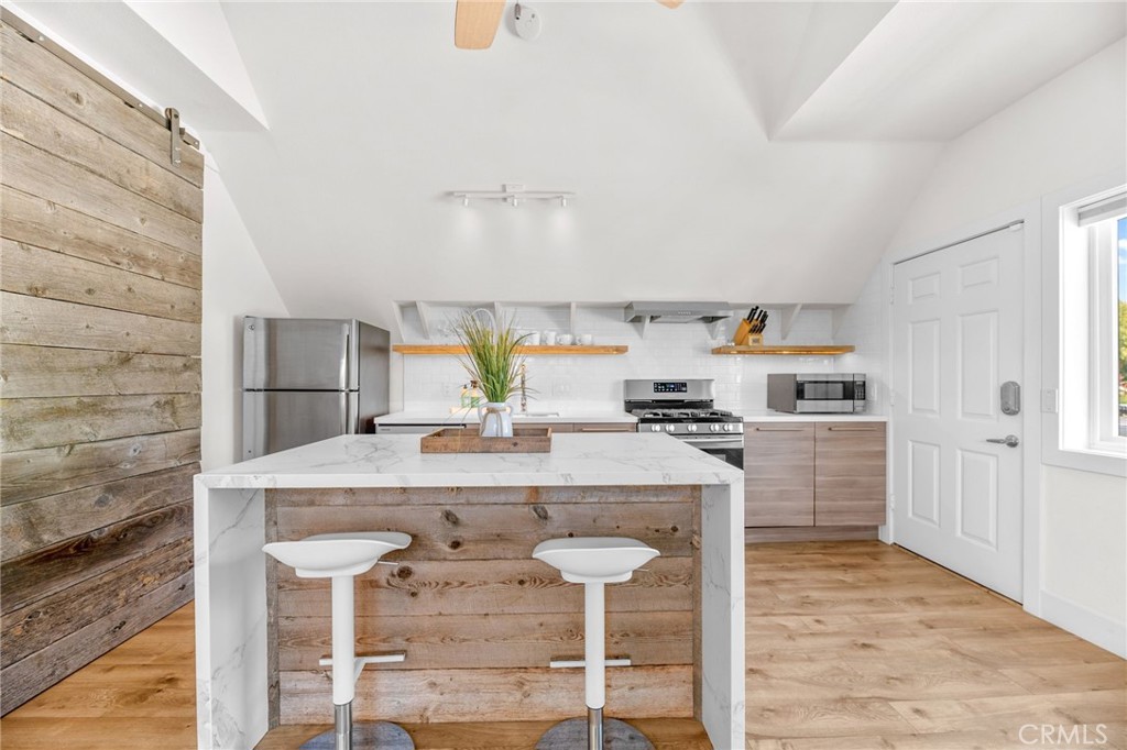 30702 Cll Pina Colada Temecula, CA 92591 - Photo 71 of 75 a kitchen with kitchen island a stove a table and chairs in it