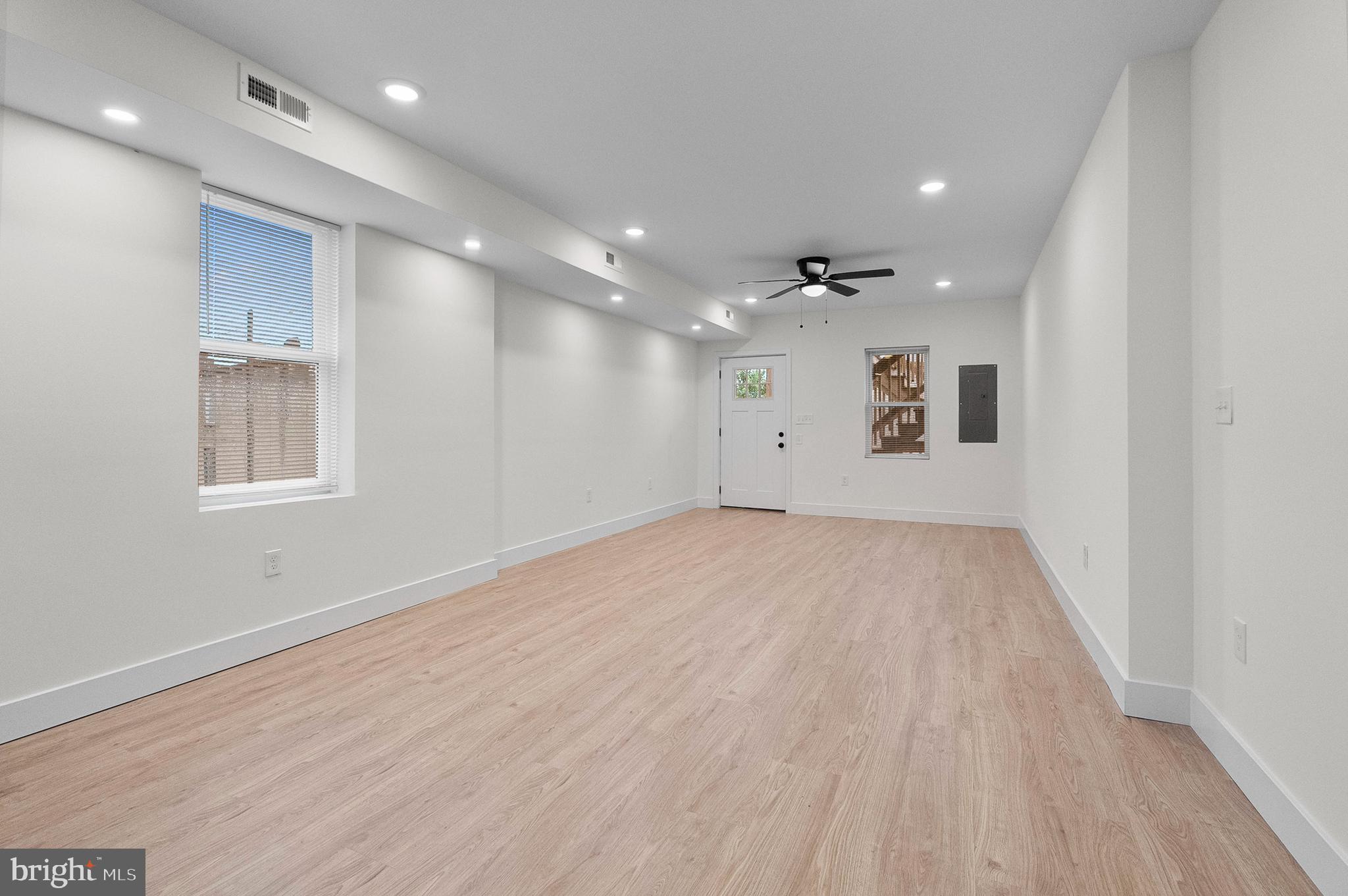 2200 East Fayette Street Baltimore, MD 21231 - Photo 20 of 23 an empty room with wooden floor and windows