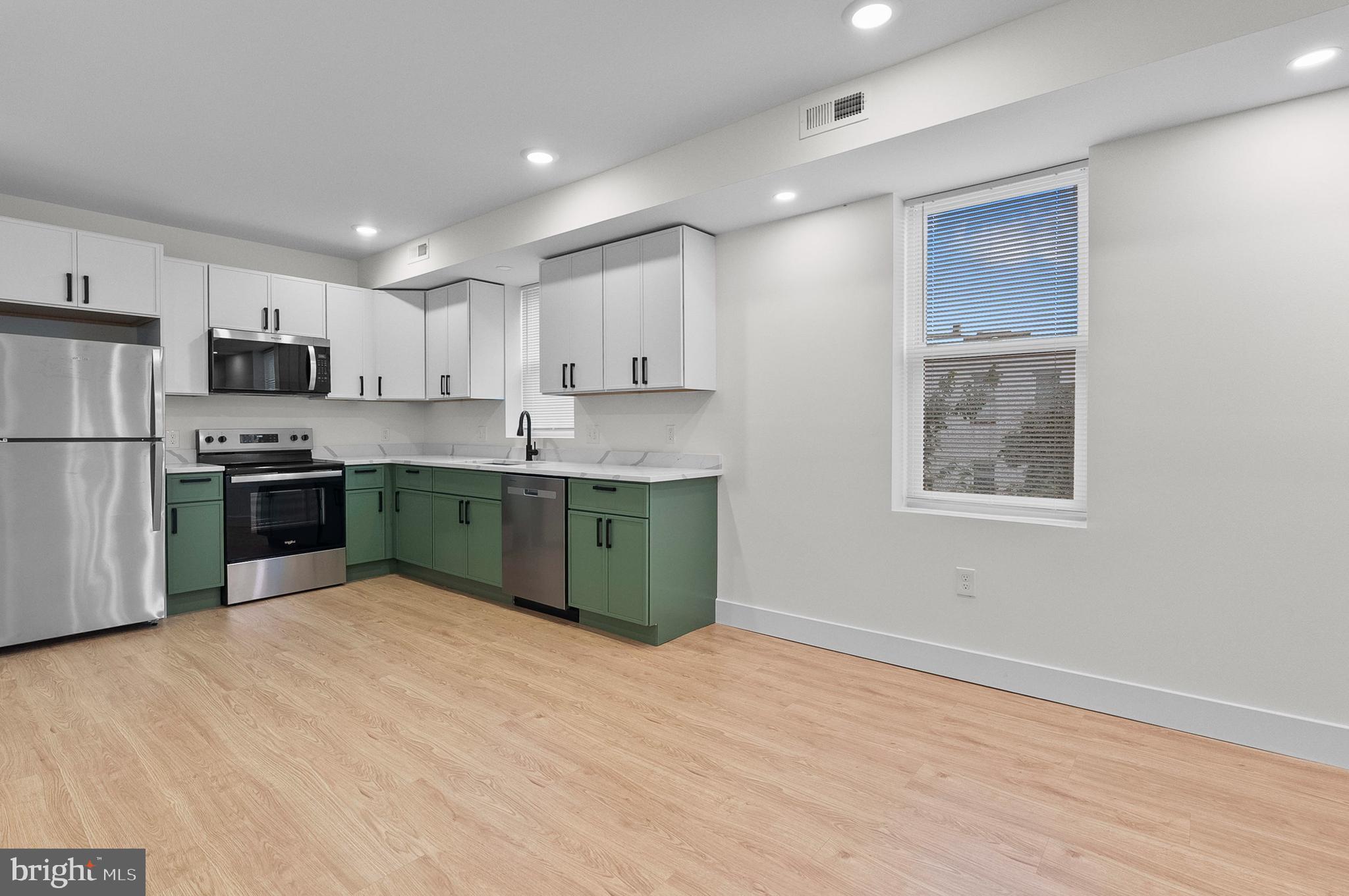2200 East Fayette Street Baltimore, MD 21231 - Photo 4 of 23 a kitchen with stainless steel appliances granite countertop a stove top oven a refrigerator a sink and dishwasher with wooden floor