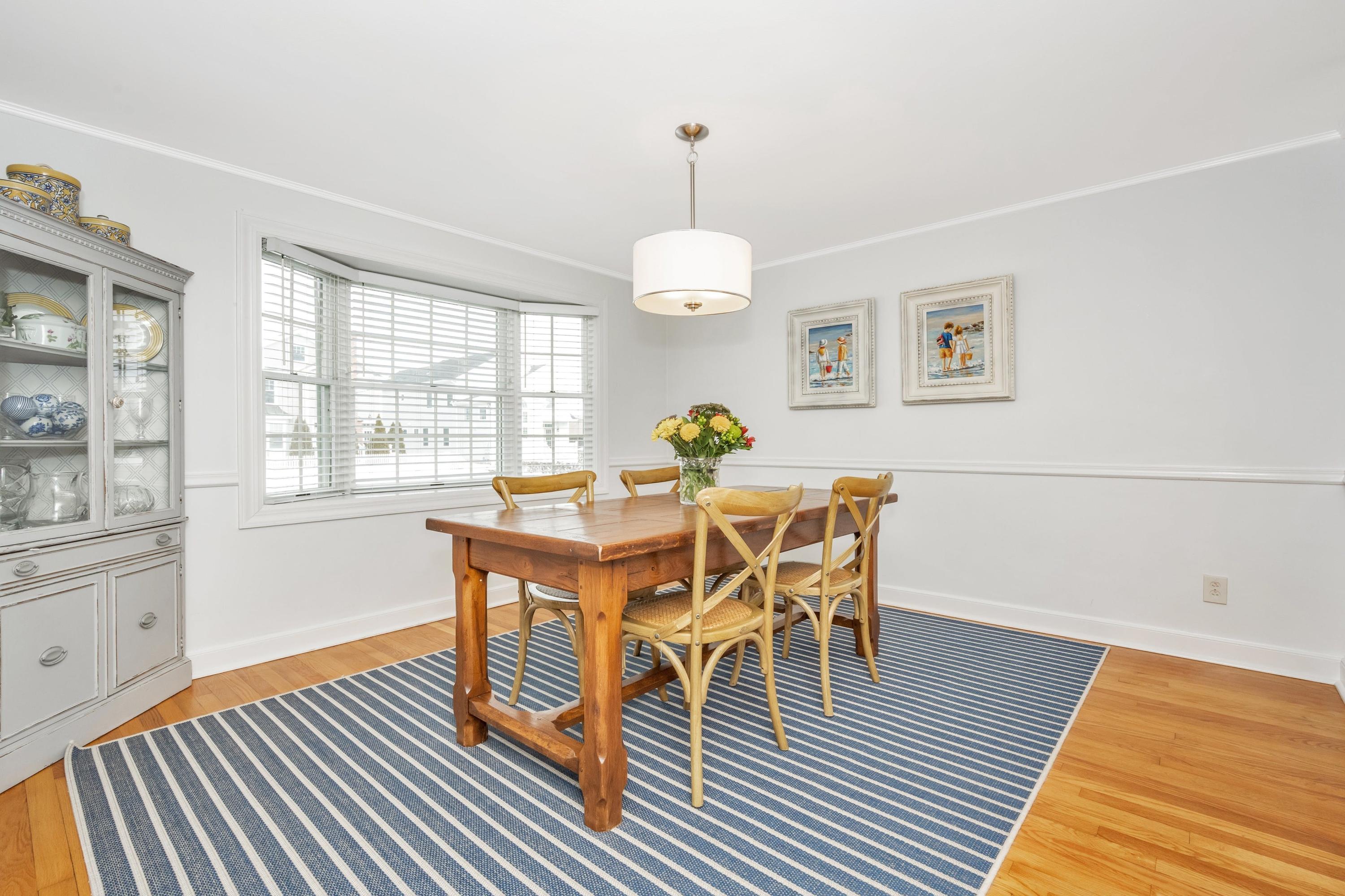879 Oldfield Road Fairfield, CT 06824 - Photo 6 of 26 a dining room with furniture a chandelier and wooden floor