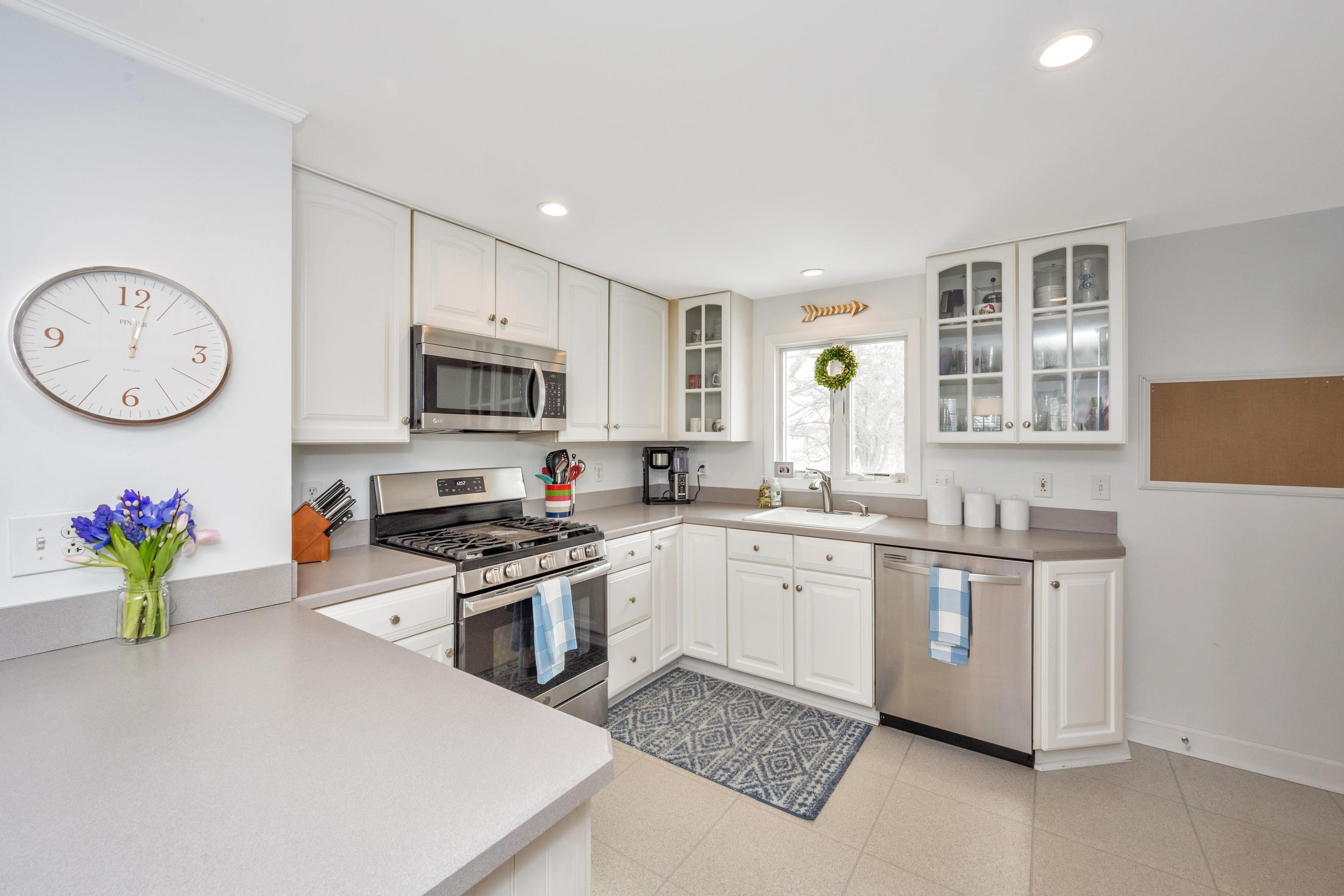 879 Oldfield Road Fairfield, CT 06824 - Photo 9 of 26 a kitchen with a sink a stove a microwave and cabinets