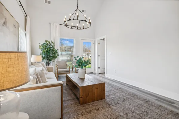 a bedroom with a large bed and a chandelier