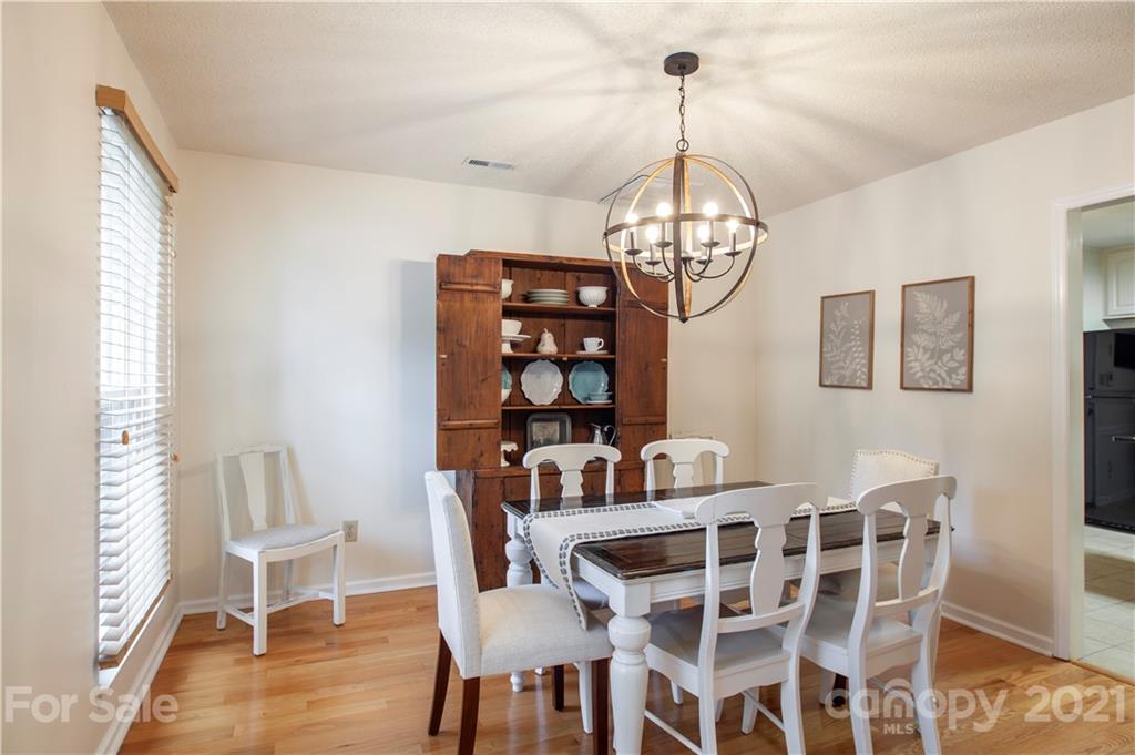 2512 Olde Whitehall Road Charlotte, NC 28273 - Photo 9 of 25 a view of a dining room with furniture a chandelier and wooden floor
