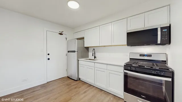 a kitchen with stainless steel appliances a stove microwave and sink
