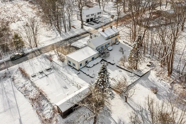 a view of a house with a yard covered with snow in the background