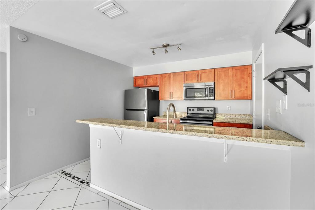 10626 Deergrass Lane Orlando, FL 32821 - Photo 11 of 41 a kitchen with stainless steel appliances a stove refrigerator sink and cabinets
