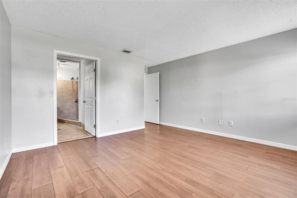 10626 Deergrass Lane Orlando, FL 32821 - Photo 15 of 41 a view of an empty room with wooden floor and a ceiling fan