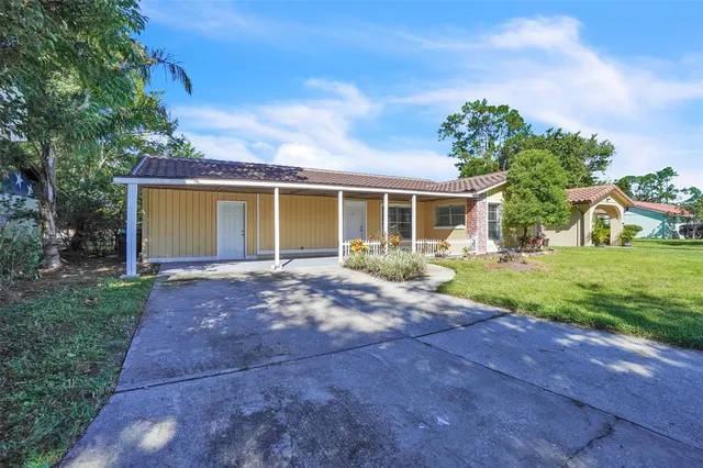 a view of a house with backyard and a tree