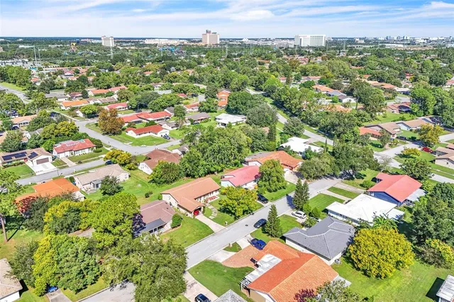 an aerial view of residential houses with outdoor space and trees all around