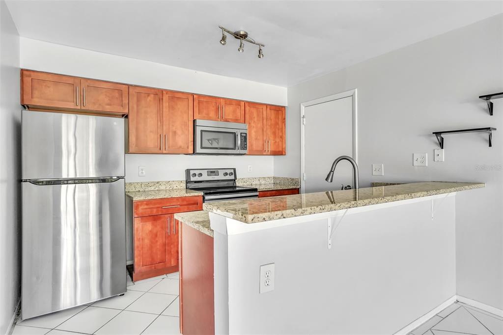 10626 Deergrass Lane Orlando, FL 32821 - Photo 4 of 41 a kitchen with stainless steel appliances granite countertop a refrigerator sink and cabinets