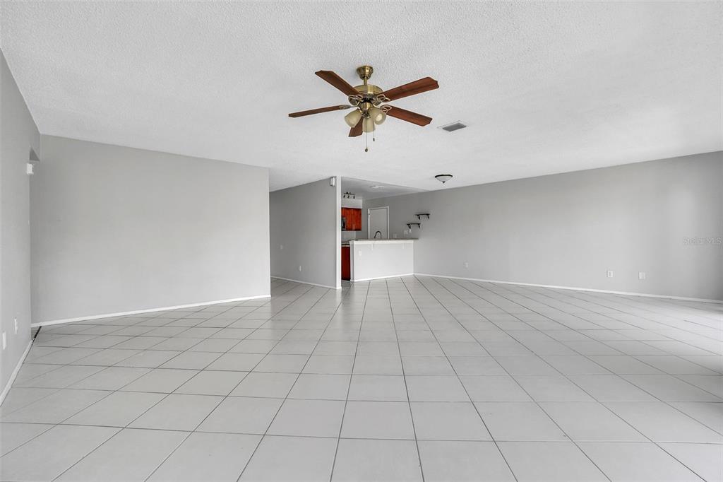 10626 Deergrass Lane Orlando, FL 32821 - Photo 7 of 41 a view of a livingroom with a ceiling fan and wooden floor