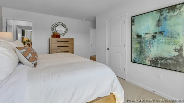 a bedroom with a bed and a painting on the wall