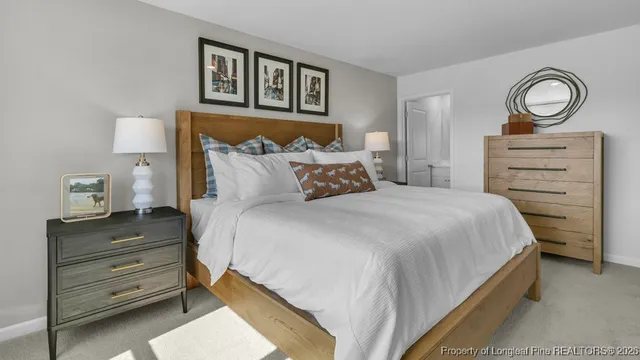 a bedroom with a bed and a lamp on dresser