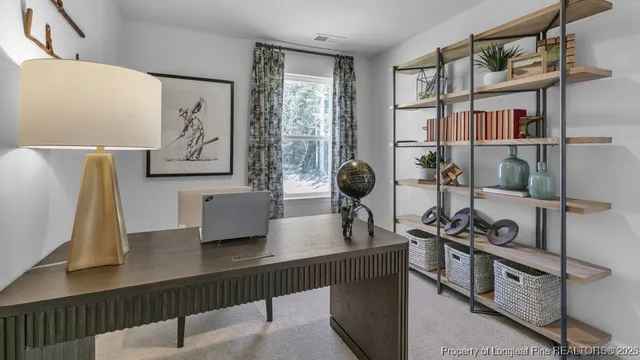 a view of a workspace with furniture and a window