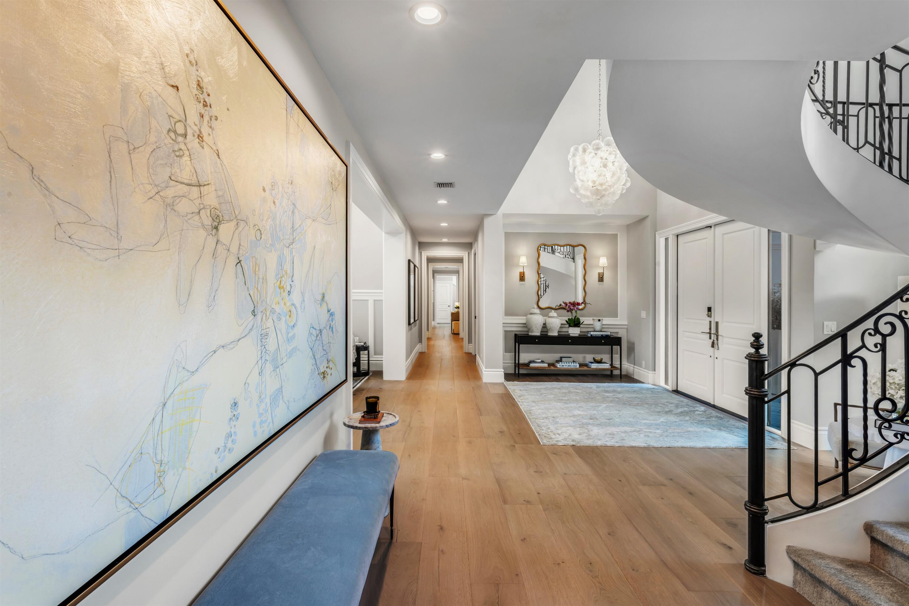 4540 Northwest 24th Avenue Boca Raton, FL 33431 - Photo 15 of 36 a hallway with wooden floor windows and a chandelier