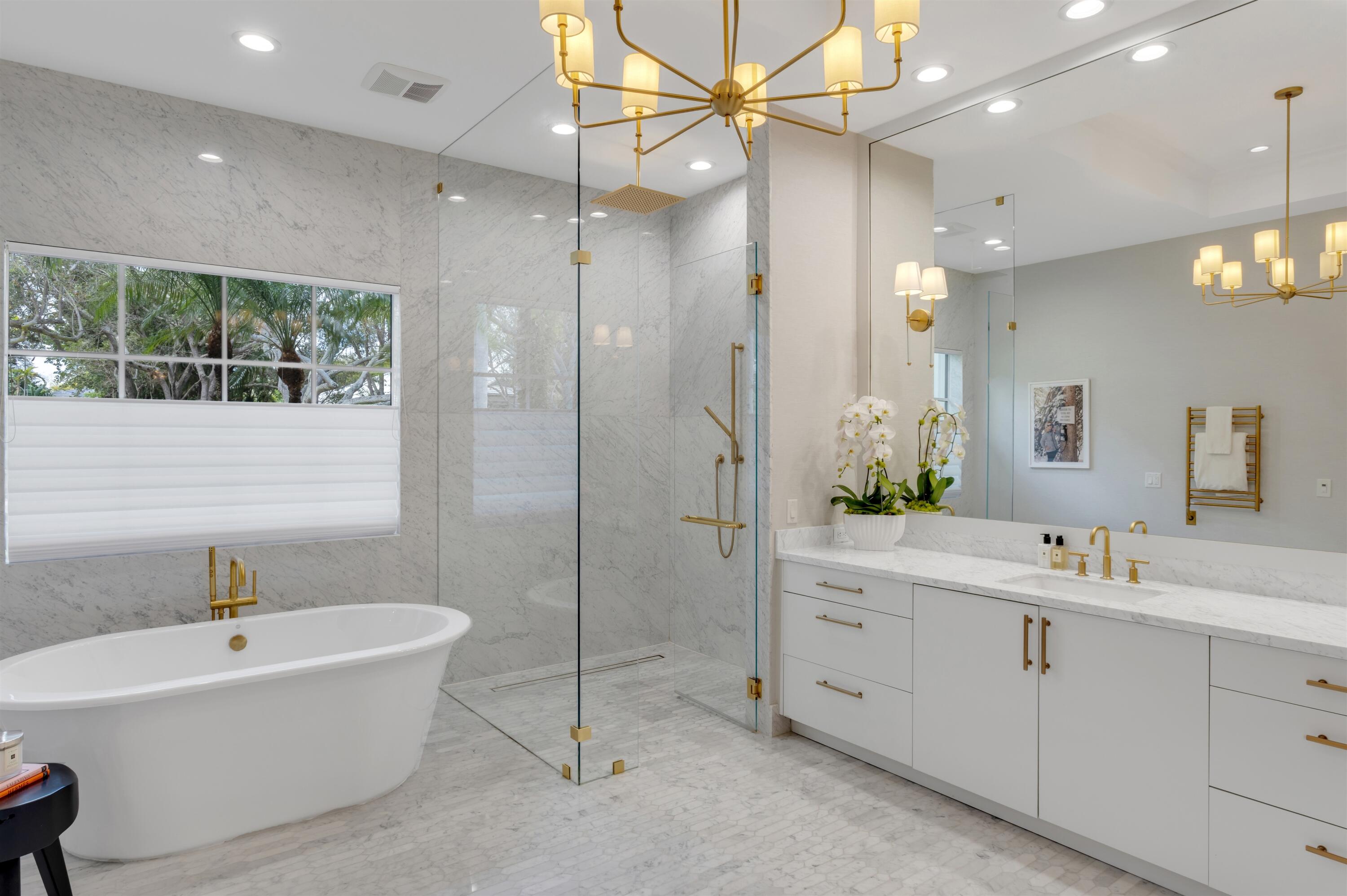 4540 Northwest 24th Avenue Boca Raton, FL 33431 - Photo 21 of 36 a bathroom with a bathtub a sink and a large mirror